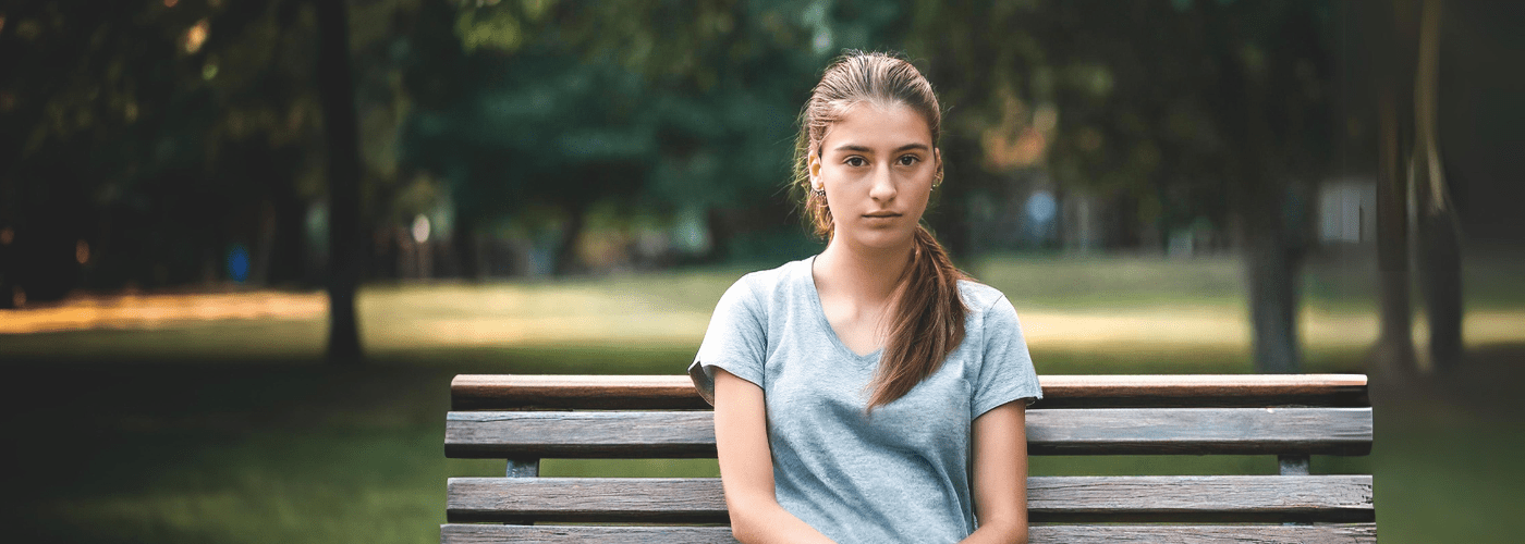 16 year old girl sitting on a park bench